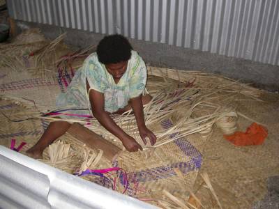 A villager at Epi Island weaves pandanus leaves into mats