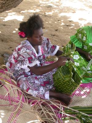 A village girl makes a basket from pandanus leaves