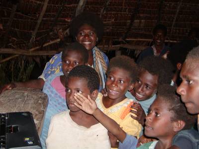The villagers crowd around to see photos