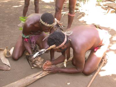 Making fire - adding hot embers to coconut husks